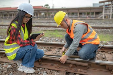 Tren istasyonunda çalışan iki mühendis kalkınma yönergeleri hakkında danışmanlık yapıyor.