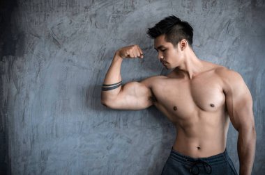 Spor salonunda kaslı Asyalı bir adamın portresi, sağlık için egzersiz.