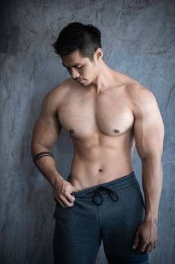 Spor salonunda kaslı Asyalı bir adamın portresi, sağlık için egzersiz.