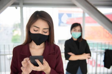 Asyalı kadınlar COVID-19 virüsünü korumak için yüz maskesi takıyorlar.