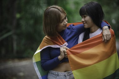 Kızlı bir çift, LGBT Onur Ayı konsepti, Asyalı yakışıklı erkek makyaj ve kadın kıyafeti, Gay Özgürlük Günü, beyaz arka planda ikili olmayan portre