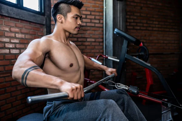 ジムで働いているハンサムな男 スポーツで競争するために重量挙げをしているアジアの男 背中のトレーニング筋肉のための理髪店を引き出す — ストック写真