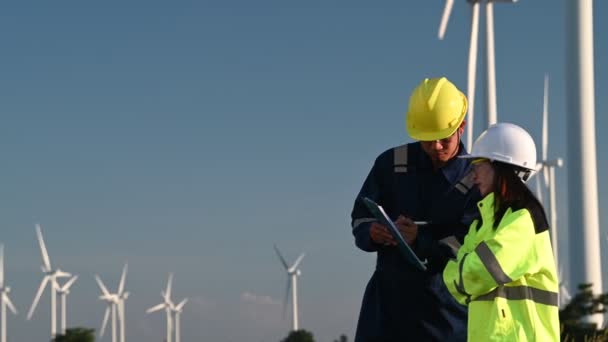 Two Engineers Working Holding Report Wind Turbine Farm Power Generator — Stock Video