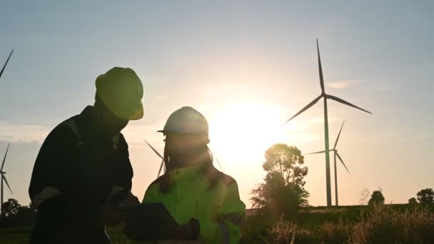 タイの山にある風力発電所で働く2人のエンジニア 技術者の男性と女性が仕事について話し合う — ストック動画