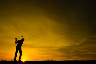 Siluet Asyalı golfçü güzel günbatımında golf oynuyor