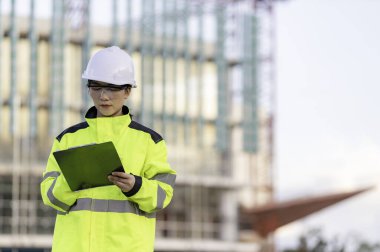 Tayland 'da büyük bir inşaat projesinin şantiyesinde çalışan Asyalı mühendis inşaat alanında fazla mesai yapıyor.