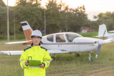 Teknisyen uçağın motorunu tamir ediyor, kadın uzay mühendisliği uçak motorlarını kontrol ediyor, Asyalı tamirci uçak motorlarını kontrol ediyor.