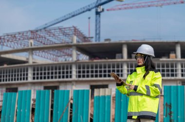 Tayland 'da büyük bir inşaat projesinin şantiyesinde çalışan Asyalı mühendis inşaat alanında fazla mesai yapıyor.