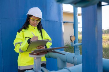 Çevre mühendisleri atık su arıtma tesislerinde çalışıyor. Su ikmali yapan kadın tesisatçı teknisyen.