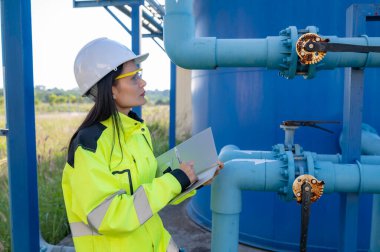 Çevre mühendisleri atık su arıtma tesislerinde çalışıyor. Su ikmali yapan kadın tesisatçı teknisyen.