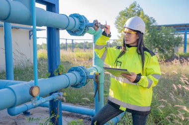 Çevre mühendisleri atık su arıtma tesislerinde çalışıyor. Su ikmali yapan kadın tesisatçı teknisyen.