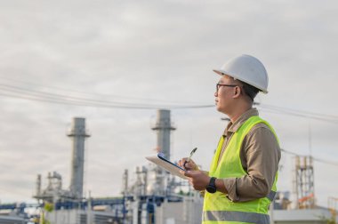 Petrol ve gaz rafinerisi fabrikasında çalışan Asyalı petrokimya mühendisi elektrik santrali enerji imalatında çalışan insan işçi mühendisi.