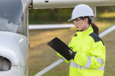 Teknisyen uçağın motorunu tamir ediyor, kadın uzay mühendisliği uçak motorlarını kontrol ediyor, Asyalı tamirci uçak motorlarını kontrol ediyor.