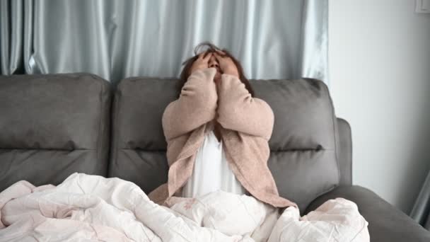 アジアの病気の女性はソファに座って家にいます 女性は悪い感じました 横になって休みたいです 薬を服用 自宅で隔離してCovid 19を治療 — ストック動画
