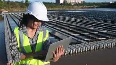 Yüzen güneş çiftliğinde çalışan Asyalı mühendis, yenilenebilir enerji, teknisyen ve yatırımcı güneş panelleri güneş enerjisi kurulumundaki panelleri kontrol ediyor