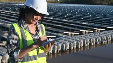 Yüzen güneş çiftliğinde çalışan Asyalı mühendis, yenilenebilir enerji, teknisyen ve yatırımcı güneş panelleri güneş enerjisi kurulumundaki panelleri kontrol ediyor