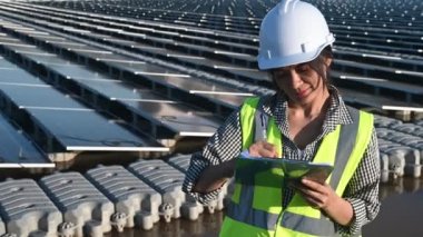 Yüzen güneş çiftliğinde çalışan Asyalı mühendis, yenilenebilir enerji, teknisyen ve yatırımcı güneş panelleri güneş enerjisi kurulumundaki panelleri kontrol ediyor