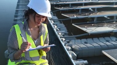 Yüzen güneş çiftliğinde çalışan Asyalı mühendis, yenilenebilir enerji, teknisyen ve yatırımcı güneş panelleri güneş enerjisi kurulumundaki panelleri kontrol ediyor