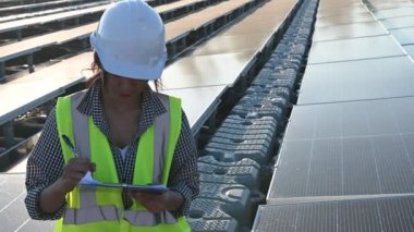 Yüzen güneş çiftliğinde çalışan Asyalı mühendis, yenilenebilir enerji, teknisyen ve yatırımcı güneş panelleri güneş enerjisi kurulumundaki panelleri kontrol ediyor