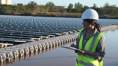 Yüzen güneş çiftliğinde çalışan Asyalı mühendis, yenilenebilir enerji, teknisyen ve yatırımcı güneş panelleri güneş enerjisi kurulumundaki panelleri kontrol ediyor