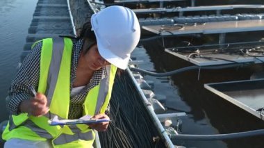 Yüzen güneş çiftliğinde çalışan Asyalı mühendis, yenilenebilir enerji, teknisyen ve yatırımcı güneş panelleri güneş enerjisi kurulumundaki panelleri kontrol ediyor