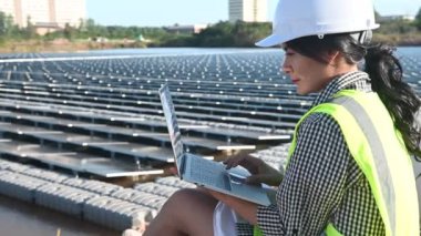 Yüzen güneş çiftliğinde çalışan Asyalı mühendis, yenilenebilir enerji, teknisyen ve yatırımcı güneş panelleri güneş enerjisi kurulumundaki panelleri kontrol ediyor