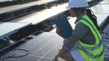 Yüzen güneş çiftliğinde çalışan Asyalı mühendis, yenilenebilir enerji, teknisyen ve yatırımcı güneş panelleri güneş enerjisi kurulumundaki panelleri kontrol ediyor