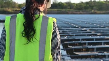 Yüzen güneş çiftliğinde çalışan Asyalı mühendis, yenilenebilir enerji, teknisyen ve yatırımcı güneş panelleri güneş enerjisi kurulumundaki panelleri kontrol ediyor