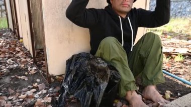 Asyalı adam yan yolda evsiz, yabancı biri yolda yalnız yaşamak zorunda çünkü ailesi yok..