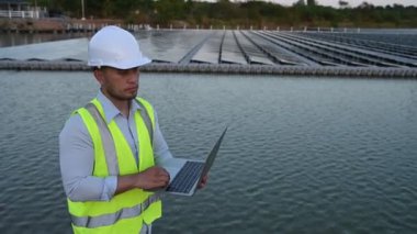 Yüzen güneş çiftliğinde çalışan Asyalı mühendis, yenilenebilir enerji, teknisyen ve yatırımcı güneş panelleri güneş enerjisi kurulumundaki panelleri kontrol ediyor