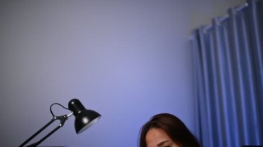 Güzel Asyalı kadın gece evde çalışıyor, şirketten bir sürü iş, eve iş getiriyor, ev konseptinden çalışıyor, sıkı çalışmaktan yorulmuş.