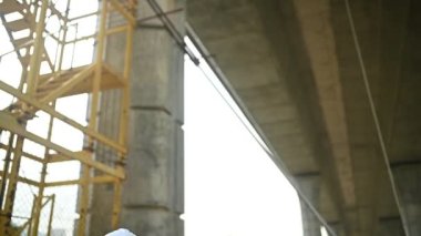 An Asian female engineer works at a motorway bridge construction site, Civil worker inspecting work on crossing construction