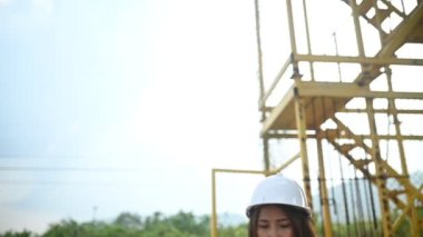 An Asian female engineer works at a motorway bridge construction site, Civil worker inspecting work on crossing construction
