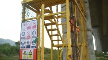 Otoyol köprüsü şantiyesinde çalışan Asyalı bir kadın mühendis inşaat çalışmalarını denetliyor.