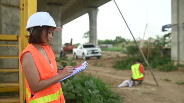 Μια Ασιάτισσα Μηχανικός Εργάζεται Εργοτάξιο Γέφυρας Αυτοκινητοδρόμου Πολιτικός Υπάλληλος Επιθεωρεί — Αρχείο Βίντεο