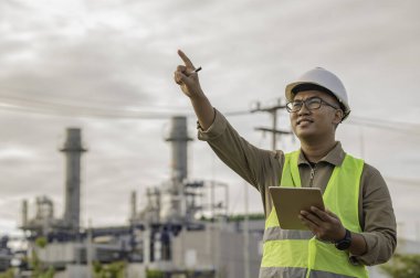 Petrol ve gaz rafinerisi fabrikasında çalışan Asyalı petrokimya mühendisi elektrik santrali enerji imalatında çalışan insan işçi mühendisi.