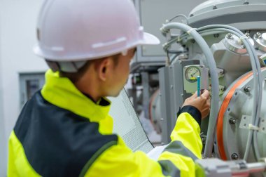 Elektrik mühendisi kontrol odasındaki elektrik dağıtım kabinesinde voltajı kontrol ediyor. Yıllık önleyici bakım, Tayland Elektrikçisi.
