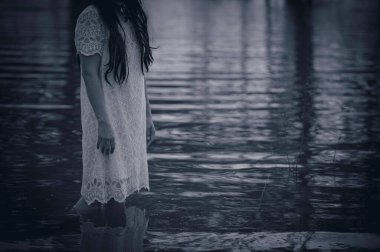 Portrait of asian woman make up ghost face at the swamp,Horror in water scene,Scary at river,Halloween poster,Thailand people