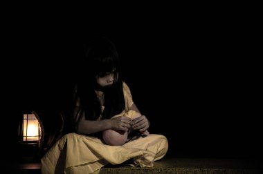 Gece üzgün çocuk hayaleti, Cadılar Bayramı festivali konsepti, 13. Cuma, korku filmi sahnesi, oyuncak bebeği olan bir kız.