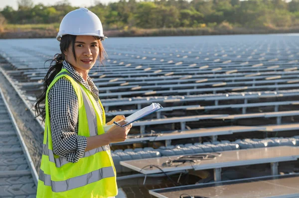 Asian engineer working at Floating solar farm,Renewable energy,Technician and investor solar panels checking the panels at solar energy installation