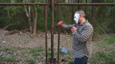 Asyalı yakışıklı adam gece olay yerinde bıçakla palyaço maskesi takıyor, Cadılar Bayramı festivali konsepti, turuncu elbiseli bir katilin korkunç fotoğrafı.