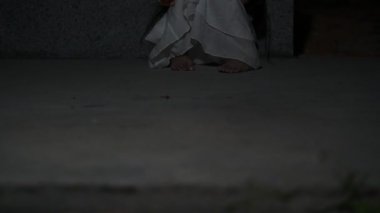 Sad child ghost at night. Halloween Festival concept. Friday 13th. Horror movie scene. A girl with doll
