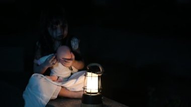 Geceleri üzgün çocuk hayalet. Cadılar Bayramı festivali konsepti. 13. Cuma. Korku filmi sahnesi. Oyuncak bebeği olan bir kız
