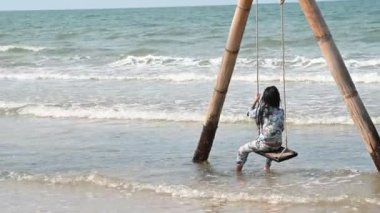 A little girl play sand at side sea beach on the sunset, Thailane people, Relax time