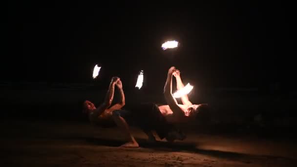 男性消防士は夜にビーチで火のショーを実行します — ストック動画