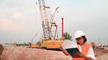 Civil engineer working at a construction site, The company manager supervises the road construction.