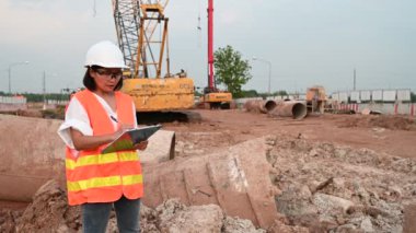 Civil engineer working at a construction site, The company manager supervises the road construction.