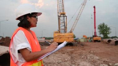 Civil engineer working at a construction site, The company manager supervises the road construction.