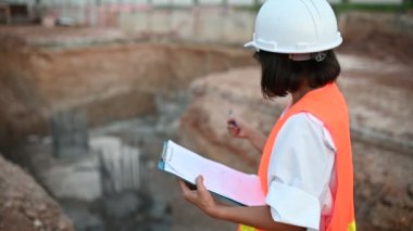 Civil engineer working at a construction site, The company manager supervises the road construction.