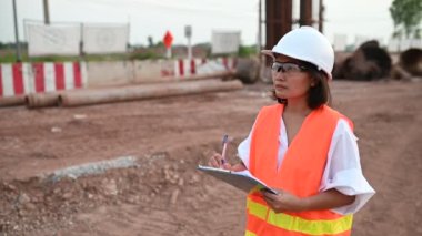 Civil engineer working at a construction site, The company manager supervises the road construction.